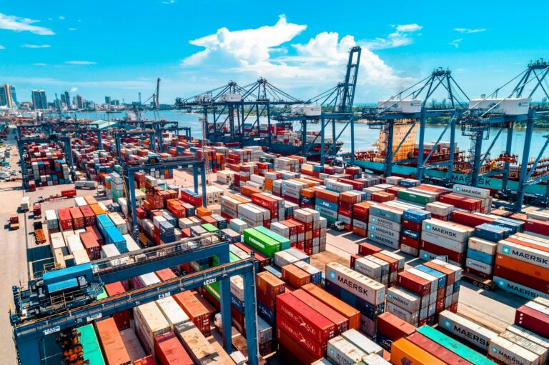 Container yard with stacked shipping containers and cranes