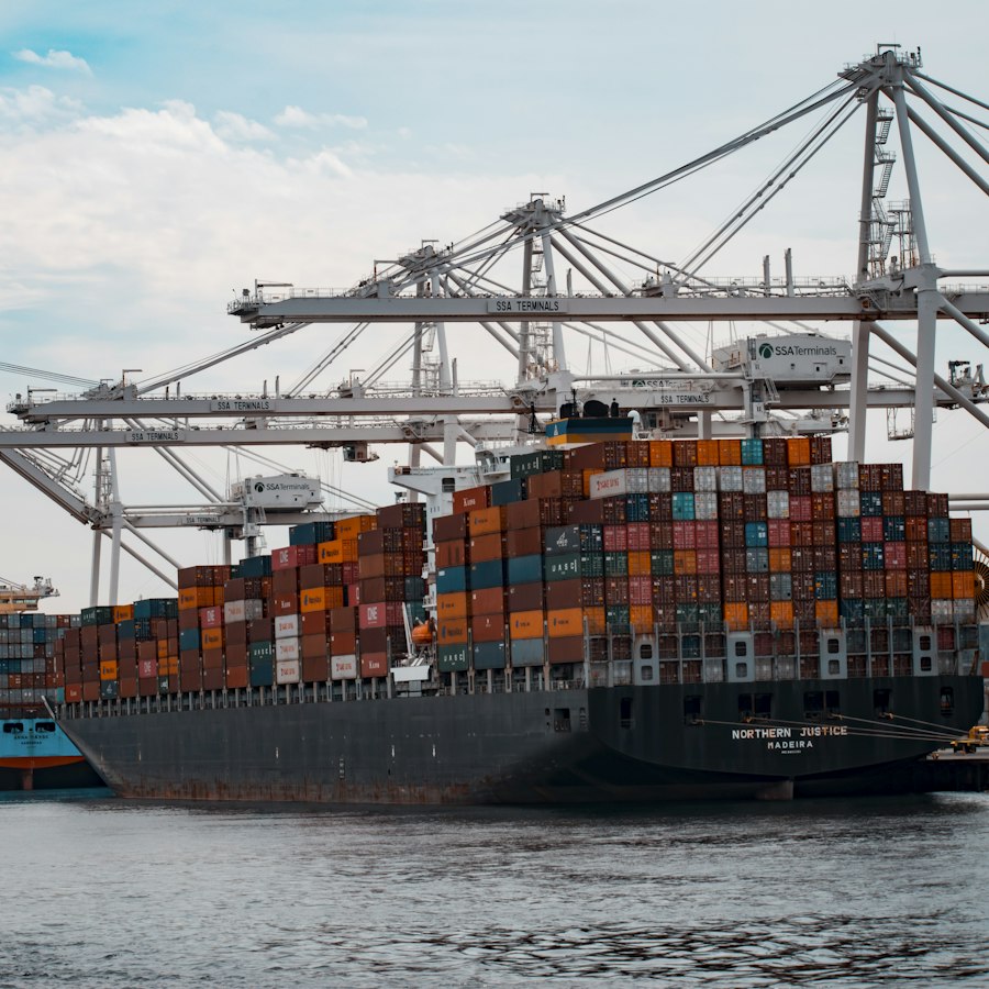 Container ship docked under port cranes