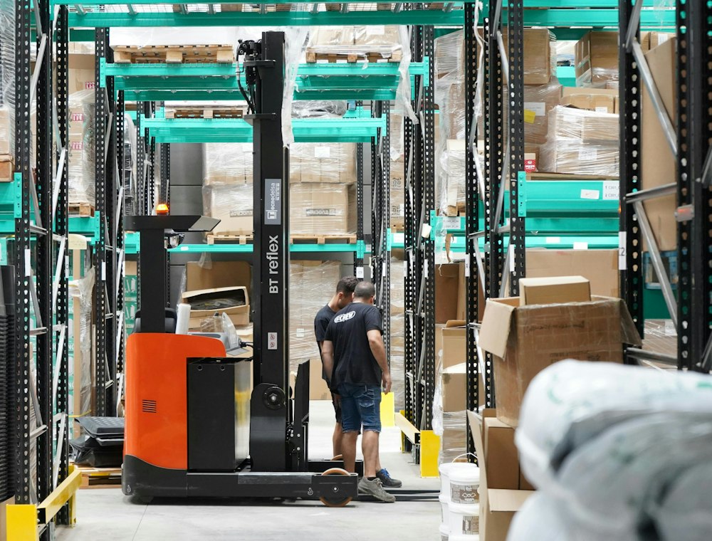 Reach truck working between modern warehouse racks