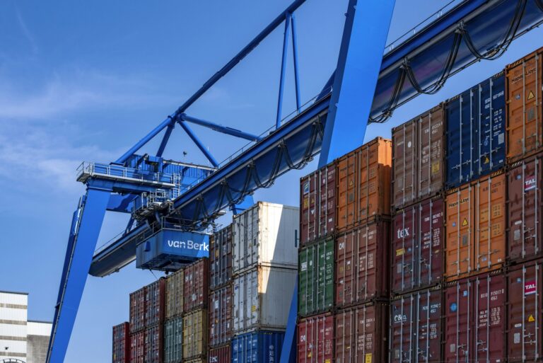 Port crane handling shipping containers for transloading